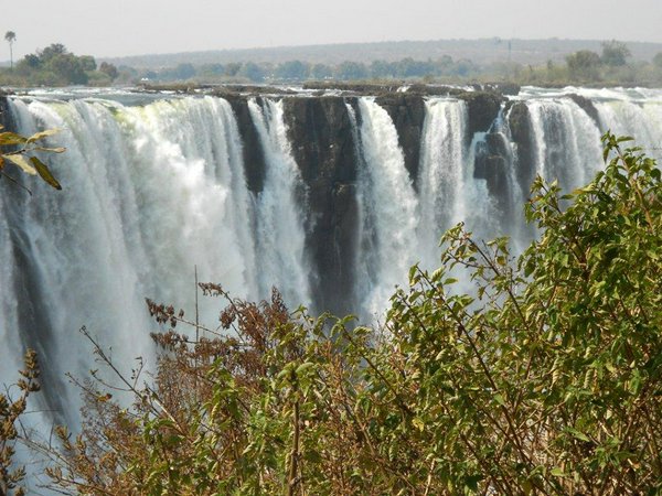 In volo dall'italia, raggiungeremo le Victoria Falls sul lato dello Zimbabwe e ci organizzeremo subito per visitare le prime meraviglie del viaggio! Le imponenti cascate, che si estendono lungo il fiume Zambesi per quasi due chilometri, sono oggi un  sito del patrimonio dell’UNESCO e rappresentano le più grandi e spettacolari cascate al mondo. Per passeggiare lungo la faglia, indosseremo degli impermeabili che ci proteggeranno dalle nuvole di vapore e acqua che salgono costantemente dal fondo della gola, creando fugaci e spettacolari arcobaleni. Volendo, potremo decidere di effettuare un volo panoramico in elicottero e osservare dall'alto questa grandiosa bellezza naturale che separa lo Zambia dallo Zimbabwe, con le sue acque che si gettano nella Batoka Gorge tra scogliere e foreste di mopane.  Con una rapido transfer in pulmino, lasceremo le cascate e raggiungeremo Kasane, città di frontiera sul confine del Botswana. Da qui entreremo nel Chobe National Park, il terzo parco per grandezza del Botswana, ma il primo per la sua ricchezza di fauna: qui infatti è presente un'enorme varietà di grandi felini oltre alla  più grande concentrazione di elefanti in Africa. A bordo di una apposita imbarcazione, esploreremo il fiume Chobe, luogo molto suggestivo e paradiso dei fotografi in cui si riuniscono migliaia di elefanti, bufali, ippopotami, coccodrilli e molte specie di antilopi e gazzelle. Dalla nostra imbarcazione, al tramonto assisteremo a uno spettacolo incredibile con il rosso infuocato del sole africano che ci saluterà colorando di arancio le acque del fiume e la savana circostante. | Avventure nel Mondo